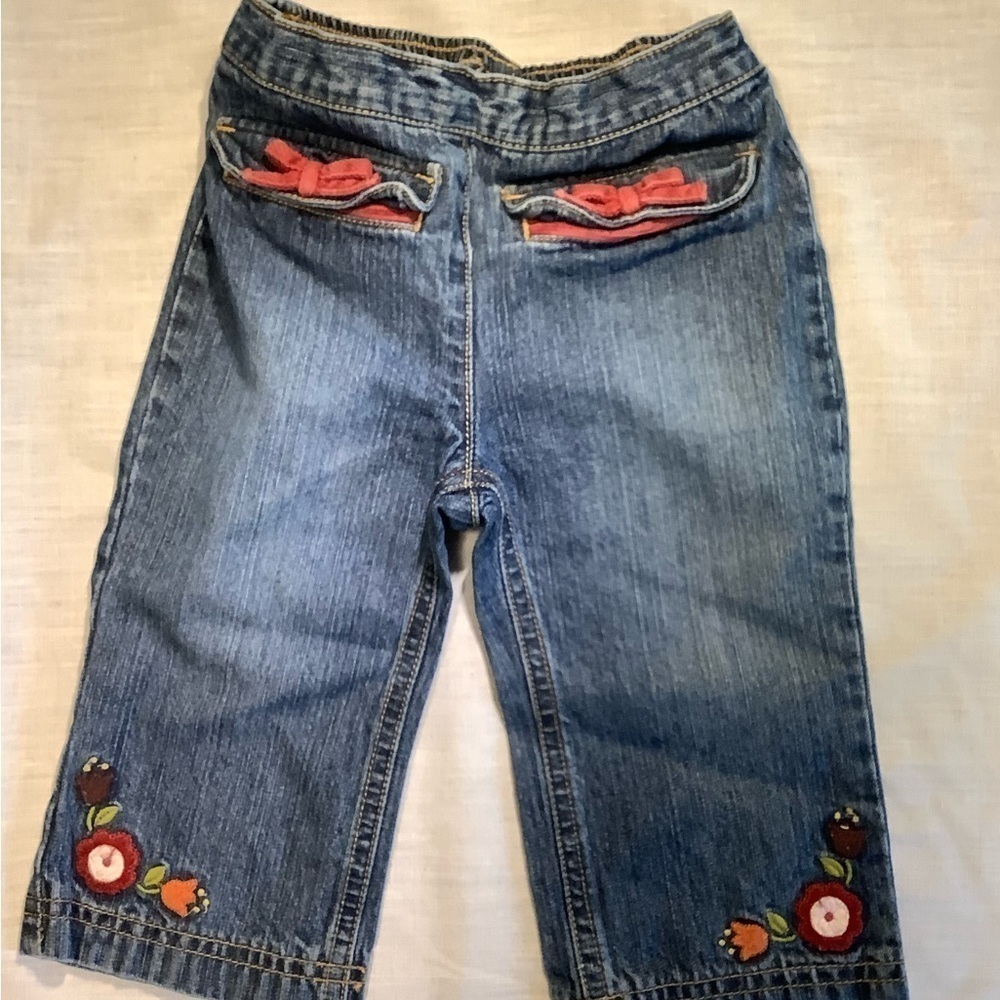 GYMBOREE blue jeans with red flowers and bows. Size 12-18 months.